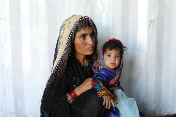 Photo: WFP/Marco Di Lauro.  ヘラート郊外の国内避難民キャンプの近くにあるWFPとUNICEFが運営する栄養クリニックでの女性と子供。