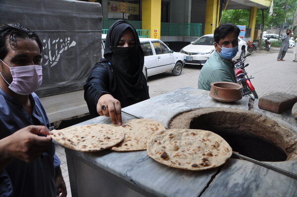 people making and buying chapatis
