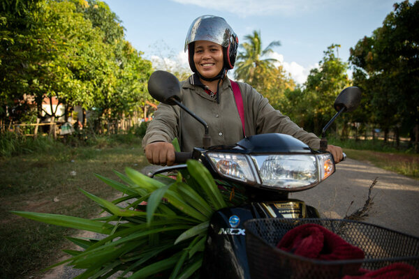 woman in helmet driving moped 