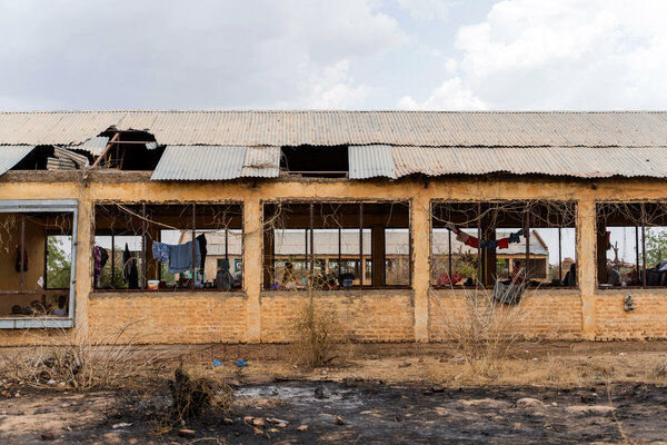 老朽化した農場の建物で生活する人々。窓は破られたままです。
