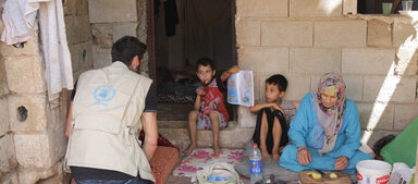 WFP staffer with woman and children