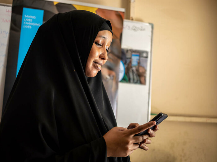 モガディシュのK4地区にある国連WFPの食料配給センターで、携帯電話を使ってオンラインショップに食料品を注文するハニ・モハメド（24歳）。