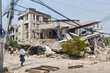 A female walks past a building destroyed by the earthquake in Myanmar