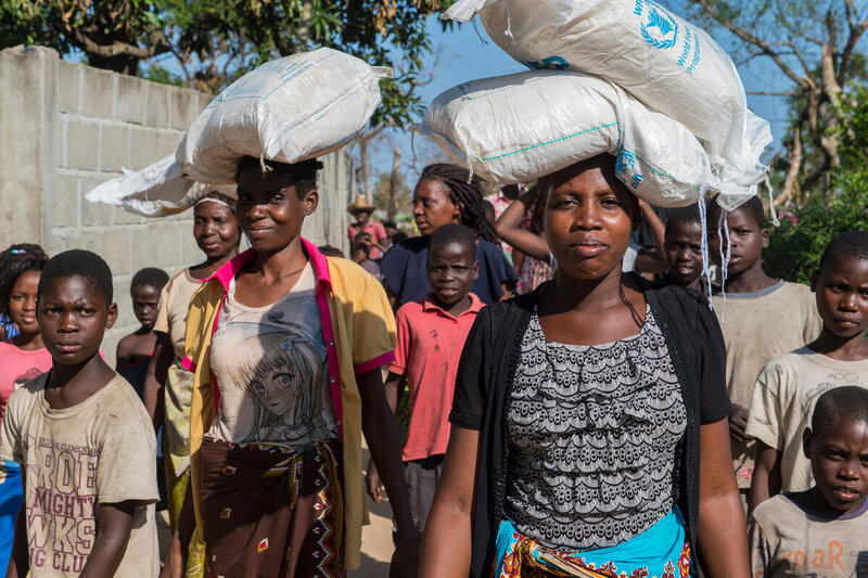 Young women, affected by Cyclone Idai carrying WFP food assistance