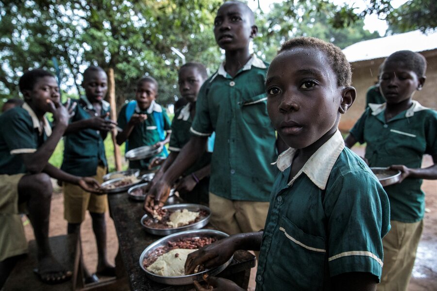 ヤンビオの学校で、国連WFPが提供したウガリと豆の温かい食事を楽しむ男子生徒たち。Photo: WFP/Gabriella Vivacqua