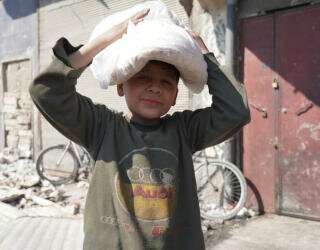 シリアのアレッポ:子供たちは親と一緒に列に並んだり、学校に行く前に一人でパンを受け取りに行きます。Photo: WFP/Hussam Al Saleh
