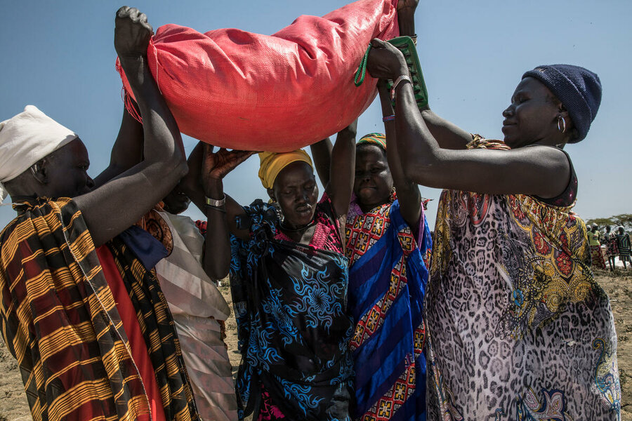 women picking red food bag in South Sudan