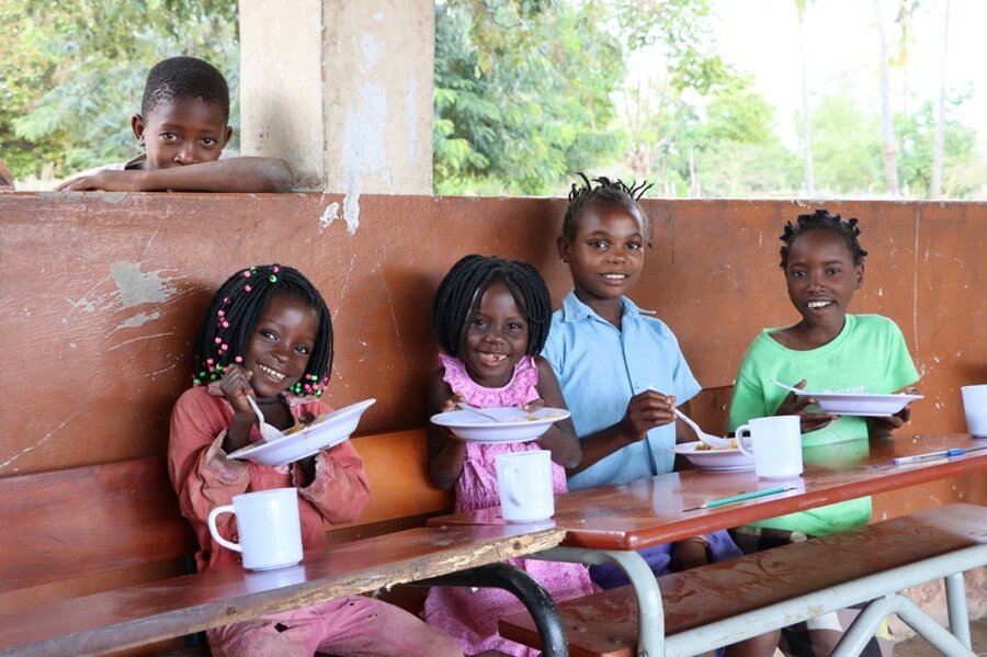 カボ・デルガド州の治安の悪化により避難してきた子どもたち。メトゥゲ地区の国連WFPから提供された温かい学校給食を食べながら。: WFP/Yuri Andrade