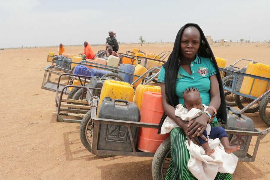 リディア・ヤクブさんと娘のビクトリアちゃんは、ナイジェリア北東部の採掘場で灯油を買うため順番待ちをしています。Photo: WFP/Patrick Fuller