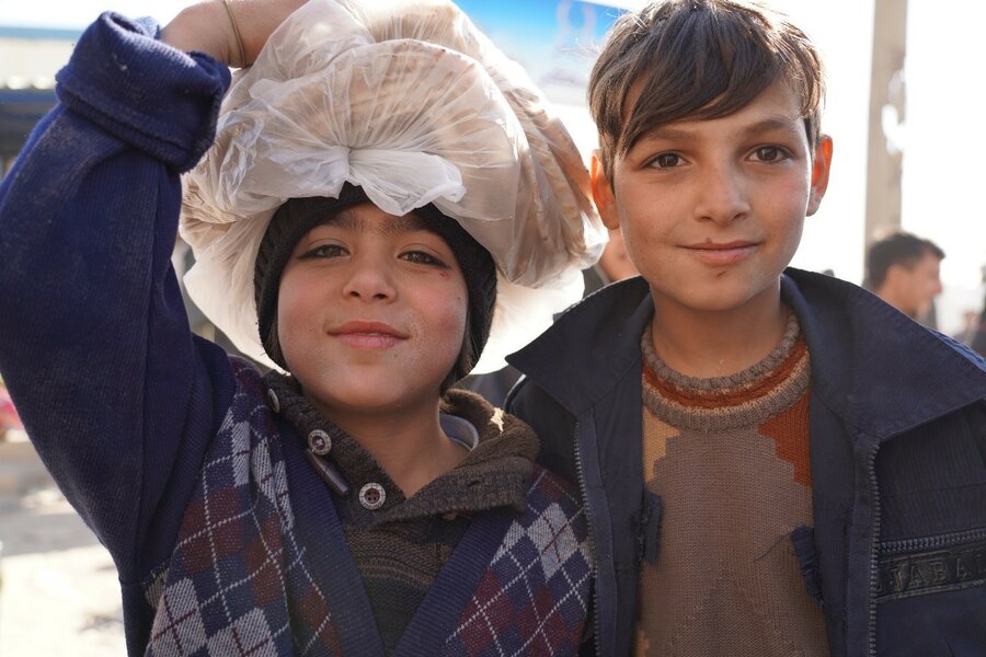 国連WFPが再建したアレッポのベーカリーで、家族のための焼きたてパンを抱える2人の少年。Two boys collect fresh bread for their families at a bakery rehabilitated by WFP in Aleppo. Photo: WFP/Jessica Lawson