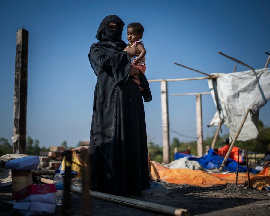 廃墟となった避難小屋で赤ちゃんを抱くノジマさん（21歳）