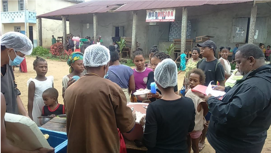 people gather around food distribution stall