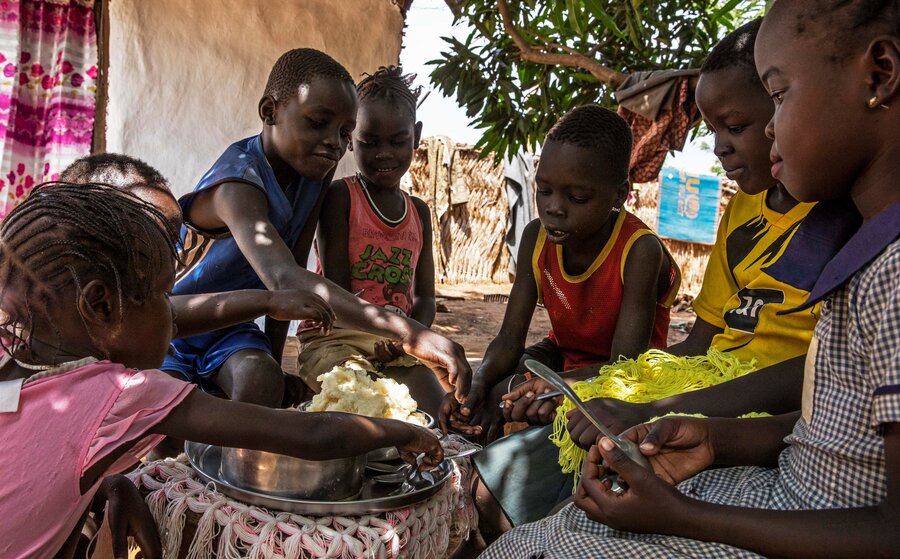 Ariet's children and friends enjoy a meal made from ingredients bought at the pop-up market. Photo: WFP/Eulalia Berlanga