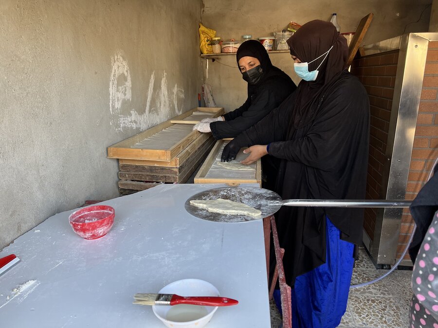 2人の女性がパン屋でイラクの伝統的なパンを作っている様子