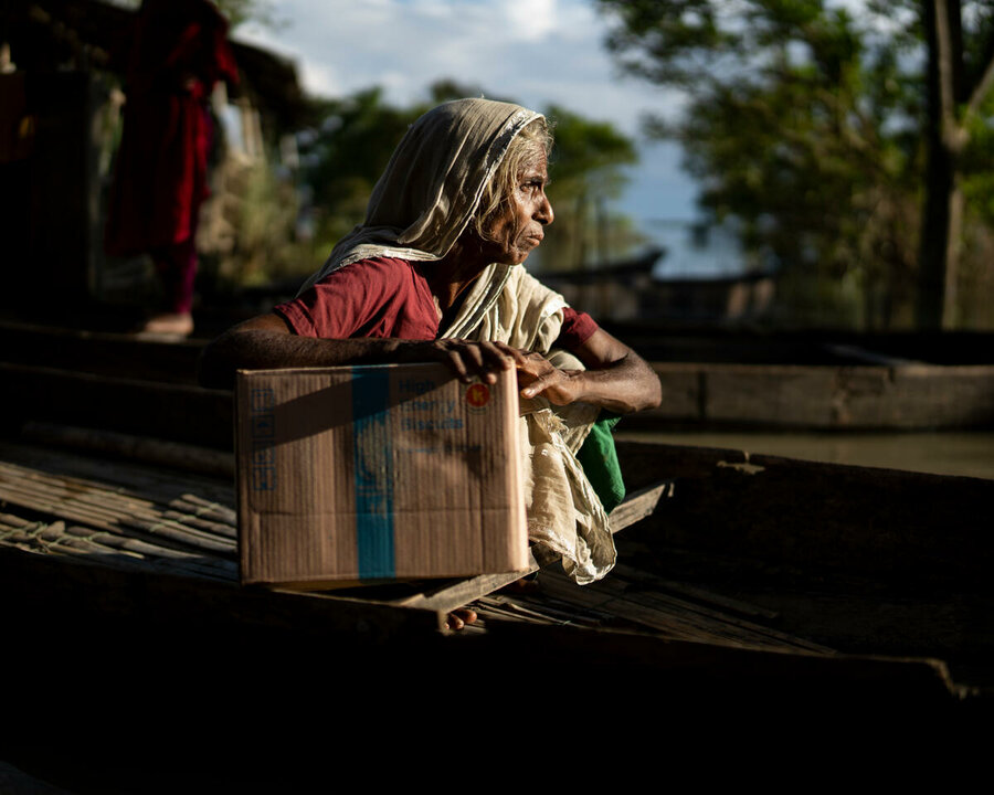 バングラデシュ： 食料支援の箱を抱える女性。彼女は、4月から5月にかけてシレットを襲った鉄砲水で家を失いました。