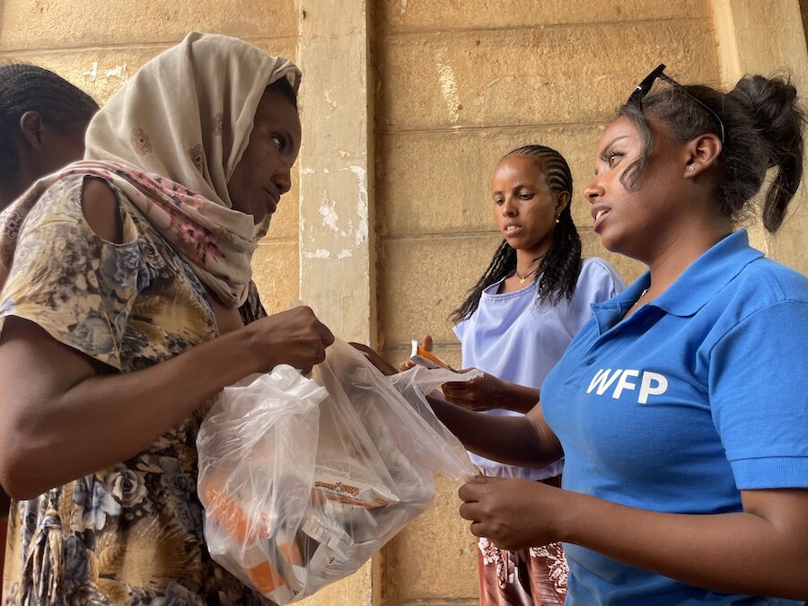 エチオピア北西部のティグライで女性に食料を届ける国連WFP職員