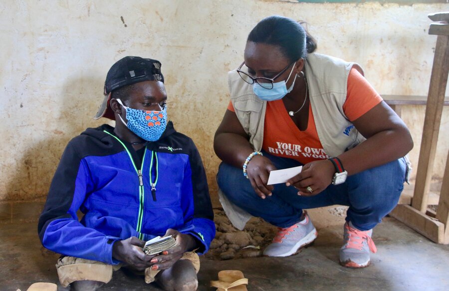 現金支援を受けた後、国連WFPスタッフと談笑するサディさん。Photo: WFP/Benjamin Anguandia