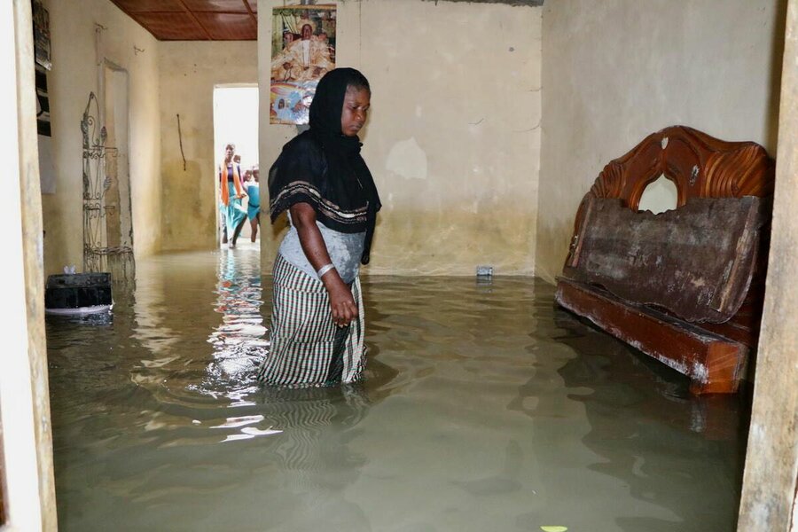 A woman wades through her flooded home outside The Gambia's capital, Banjul. Photo: WFP/Mamadou Jallow