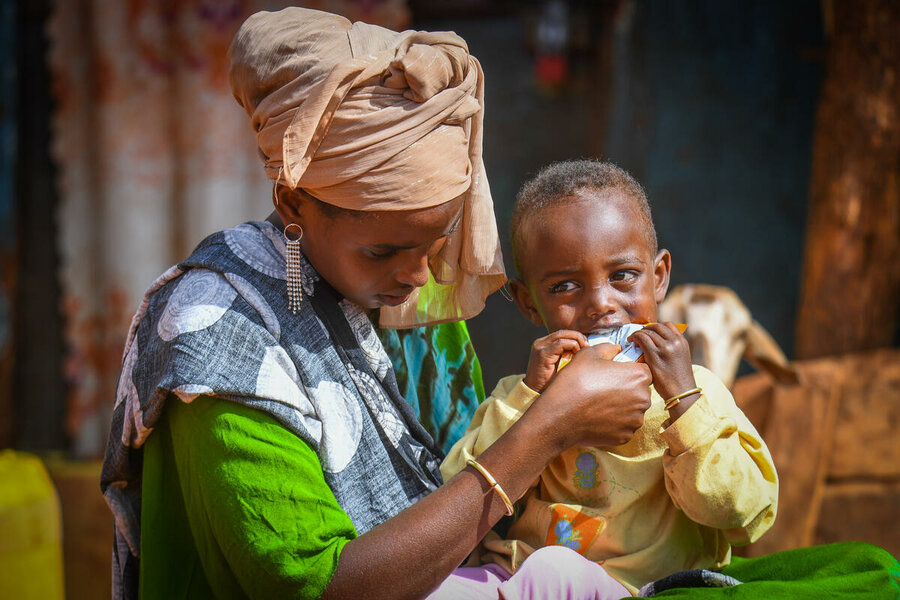 エチオピア：息子のリベン・ケフェラちゃんに、国連WFPの支援による栄養補助食品を与える母親のシェドルさん。Photo: WFP/Michael Tewelde