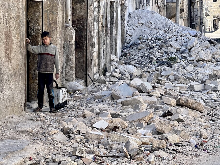 2月の地震で倒壊した建物の瓦礫の中で生活するアレッポの少年。
