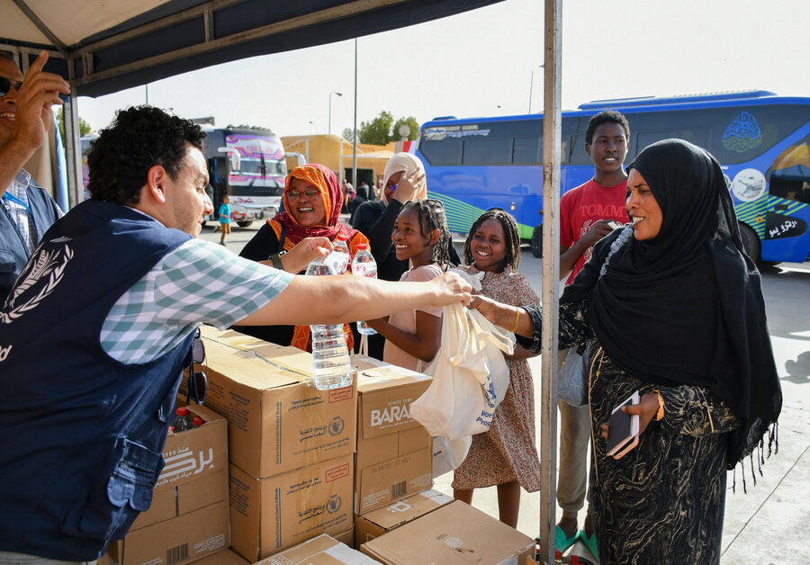 国境の町クストールの現場にいる国連WFPのチームが、スーダンから到着した人にすぐ食べられる食品のパッケージを渡します。