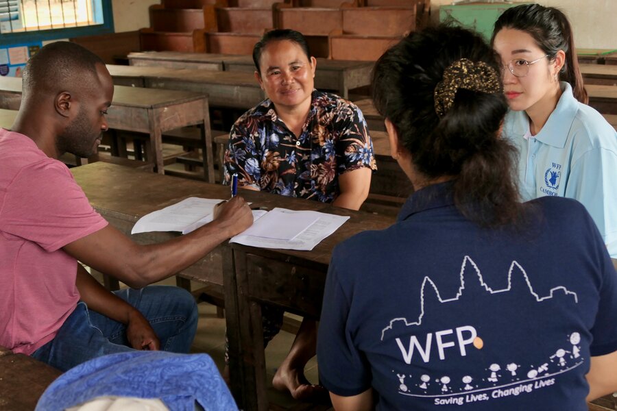 高水準の学校給食支援を維持するため、日常的なモニタリングの一環として、センさんに聴き取りをする国連WFPスタッフ。 Photo: WFP/Edward Johnson