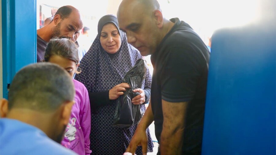 A woman in Gaza receives WFP food and other humanitarian assistance. Only a fraction of what's needed is trickling in due to border constraints. Photo: WFP