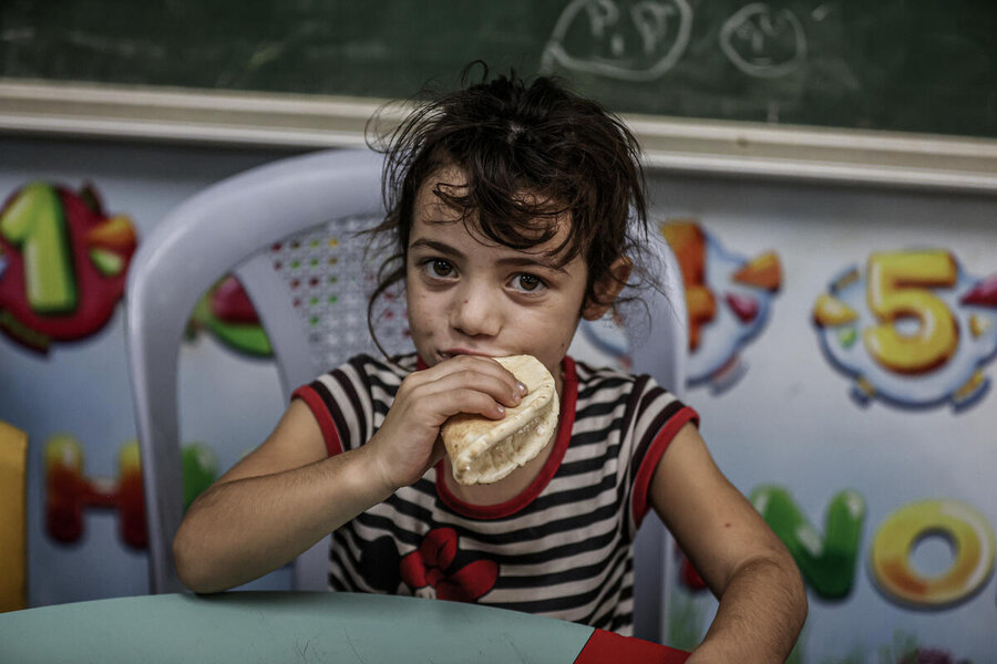 ガザの避難民家族の避難所として使われている学校で食事をとる少女。 Photo: WFP/Ali Jadallah