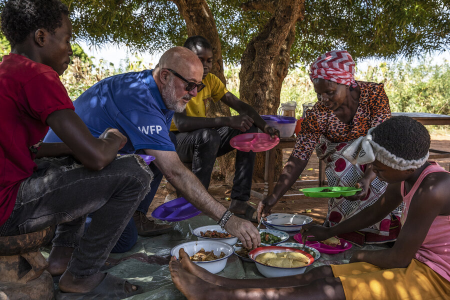 ザンビアのモンゼ地区でエメルダ・ヒチョーンボルワさんの家族と食事を共にするアンドリュー・ジマーンさん。Photo: WFP/Gabriela Vivacqua