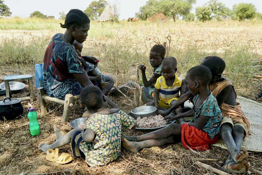 国連WFPの強靭性構築プロジェクトで収穫した米をほおばるヌーンさんの子どもたち。 Photo: WFP/Musa MahadiNoon's children tuck into the rice she has harvested from the WFP resilience-building project. Photo: WFP/Musa Mahadi