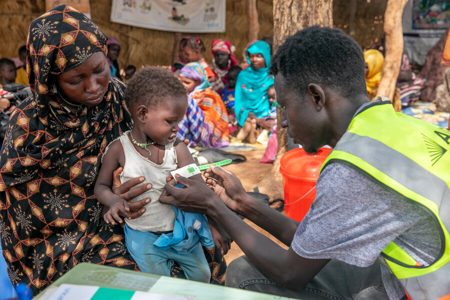 南スーダンのウェドウェイル難民居住地で、スーダンの子どもたちの栄養レベルをチェックする保健所の職員。隣国スーダンでの戦闘により、南スーダンでも飢餓と栄養不良が全国的に蔓延している。 Photo: WFP/Eulalia BerlangaHealth center staff check nutrition levels of Sudanese children at Wedweil refugee settlement in South Sudan. The war in neighbouring Sudan has deepened hunger and malnutrition countrywide. Photo: WFP/Eulalia Berlanga