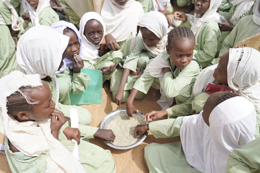 Girls tucking into a WFP school meal in Sudan's North Darfur state before the country's war broke out. Conflicts can wipe out the powerful paybacks delivered by schools and school meals. Photo: WFP/Leni Kinzli