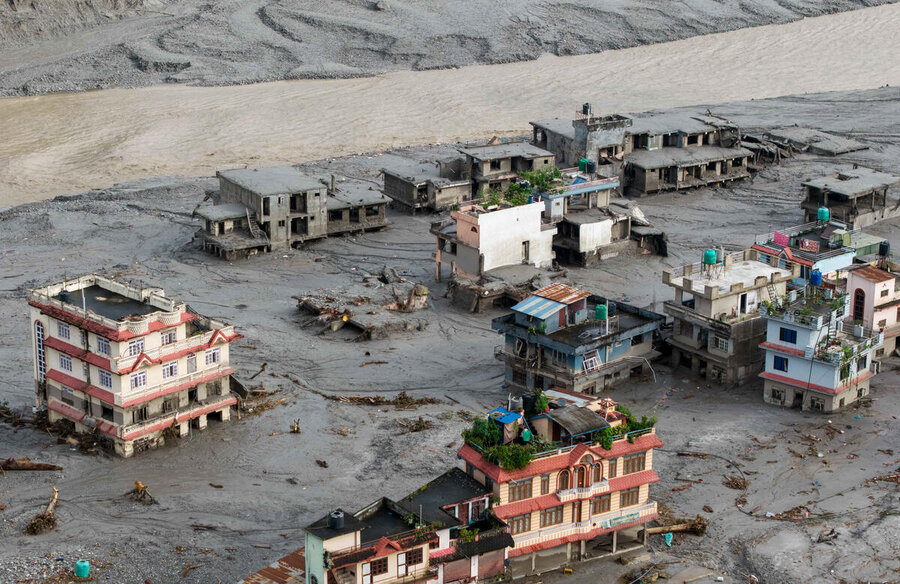 Mud and floodwaters coursing through and inundating buildings. Photo: AFP