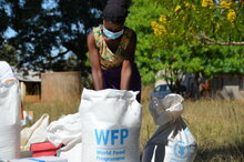 A WFP beneficiary divides shares of WFP food assistance at a distribution in Bindura district, Zimbabwe. Photo: WFP/Tatenda Macheka