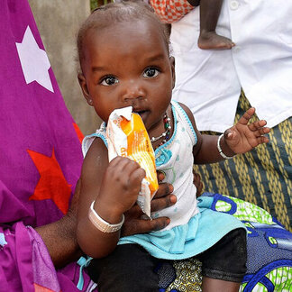Baby eating fortified and nutrient-rich snack distributed by WFP to prevent malnutrition