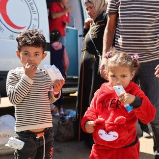 Two children are eating their WFP snacks