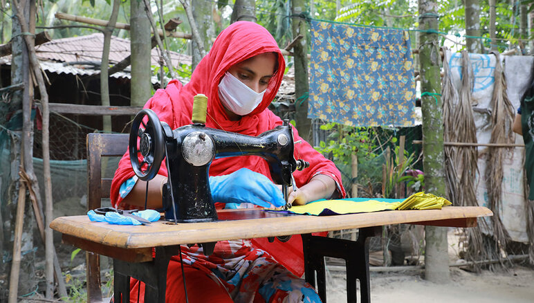 新型コロナウイルスが流行する中、国連WFPは生計プログラムを通じて、バングラデシュのコックスバザールのロヒンギャ難民やホストコミュニティの女性たちがマスクを作っている様子。作られたマスクは現地政府や人道支援機関によって人びとに配布され、女性たちは月給、職業訓練、金融リテラシー、起業するための奨学金を受け取りました。   写真：WFP/Nalifa Mehelin 